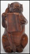 A vintage Oriental carved netsuke entitled ' smart mouse ' depicting a mouse holding its tail
