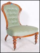 A Victorian walnur armchair being raised on turned reeded legs with ceramic castors having green