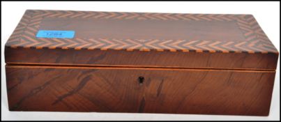 A 19th century mahogany box with herringbone boxwood and mahogany inlay. The hinged lid opening to