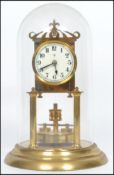 A 20th century glass domed brass anniversary clock raised on a stepped circular base with twin