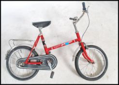 A 1970's retro childs bicycle in red colourway with decals for Hawk Miniscoot. Complete with saddle,