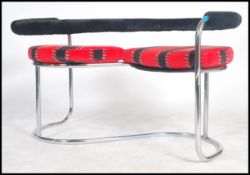 A 20th Century 'S' shaped love seat of tubular chrome construction a black padded back bar /