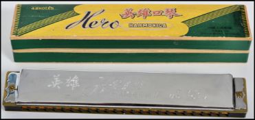A vintage Hero 48 hole Harmonica complete in original green and gilt box.