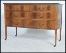 An Edwardian mahogany inlaid chest of drawers raised on square tapered legs with a series of drawers