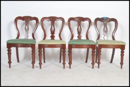 A set of 4 Victorian mahogany balloon back dining chairs being raised on turned legs with pad