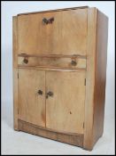 A 1930's Art Deco walnut cocktail cabinet / bar with appointed interior to the metamorphic top