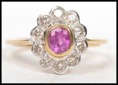 An 18ct yellow gold and ruby diamond ring of daisy style complete in the presentation case ( see