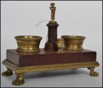 A 19th century Napoleon inspired French desk stand, raised on a set of four ormolu lion pad feet