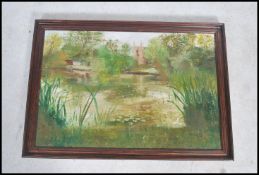 A vintage 20th century oil on canvas painting of a lake with chapel, trees and reeds, signed by