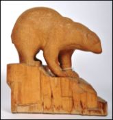 A very well carved 20th century wooden sculpture of a Polar Bear raised on a naturalistic base.