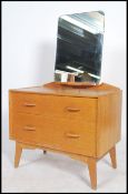 An early oak E Gomme / G-plan dressing chest raised on tapering legs with chest and mirror atop.