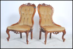 A pair of Victorian style mahogany rococo ladies armchairs being raised on cabriole legs with