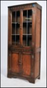 A 20th century Jacobean revival display cabinet having twin lead effect glazed drawers raised on a