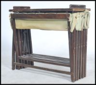 An early 20th century military canvas wooden folding bed. The metamorphic action with green canvas