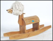 A retro 1970's slatted wood rocking horse with a mop top main being raised on sleigh beech wood