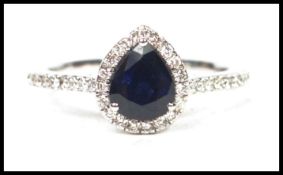 An 18ct white gold pear shaped sapphire and diamond ring adorned with approx 1.5ct's of diamonds