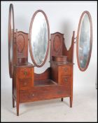 An Edwardian mahogany inlaid batwing dressing table being raised on square tapered legs with brown