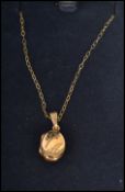 A hallmarked 9ct gold locket pendant with engraved front mounted on a fine 9ct gold necklace chain