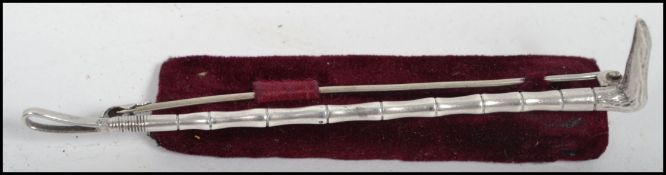 A sterling silver hunting brooch in the form of a riding crop by Alfred James How (1897-1929) with