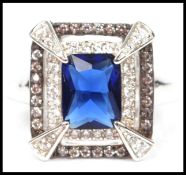 A ladies silver Art Deco style dress ring being inset with cz stones and a central sapphire