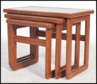 A retro 20th century vintage trio nest of tables raised on angular legs united by stretchers with