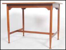 A teak Danish inspired table of small proportions raised on turned legs and pad feet united by a H
