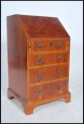 An antique syle yew wood ladies writing bureau being raised on a bracket leg base with chest of
