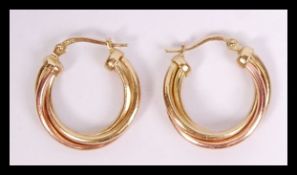 A pair of 9ct gold creole having cross over rose a