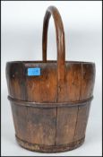 A vintage 19th century Chinese wooden bucket having shaped handle atop and metal bands.