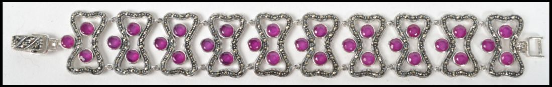 A good silver ladies bracelet being adorned with ruby and marcasite settings and chain linked