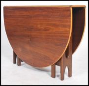 A 1970's teak wood drop leaf dining table having shaped legs in the manner of G-plan, the long