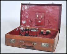 An early 20th century leather gentlemans suitcase of typical form but appointed with toiletries