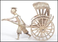 An early 20th century Chinese Export silver model of a man pulling a rickshaw, stamped 205 and