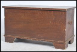 A 20th century scrumble finish blanket box having hinged top, drop handles to sides raised on