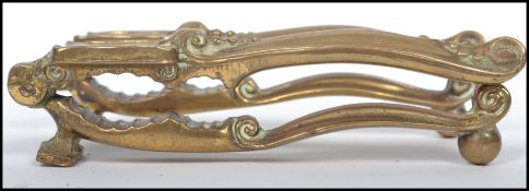Two pairs of Victorian decorative brass nut crackers of heavy construction with shaped handles to
