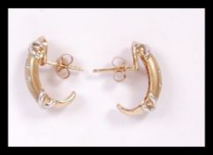 A pair of 18ct gold and diamond earrings of half c