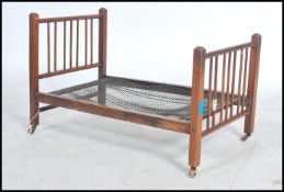 An early 20th century childs dolls bed of wooden form with mesh base( folding ) along with some