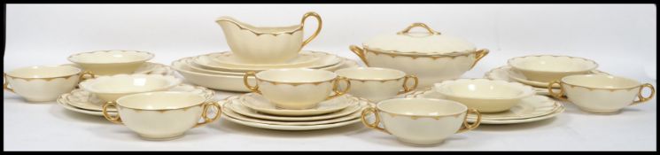 A vintage 20th century Frank Buckley ceramic dinner service having a cream ground with gilt