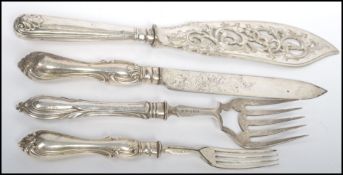 A group of four large hallmarked silver salad servers / serving cutlery to include a Georgian