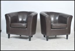 A pair of 20th century contemporary leather club armchairs. each being raised on block feet and