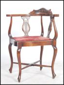 An Edwardian mahogany corner chair being raised on cabriole legs with cross stretchers having a