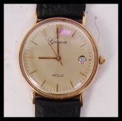 A vintage hallmarked 9ct gold Geneve watch having day aperture, baton numerals and winder to side