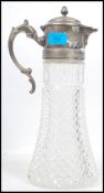 An early 20th century cut glass claret jug having silver plated mounts and lid with acorn finial