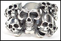 A 20th century silver ring in the brutalist style being embossed cast with sculls.