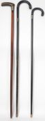 A group of three 19th and 20th century walking sticks / promenade canes, each fitted with applied