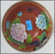An Oriental Chinese cloisonne bowl having a gilt painted foot having a red ground with floral sprays