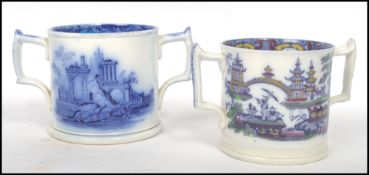 A pair of 19th century Staffordshire blue and white twin handled loving cups, each with country