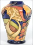 A Moorcroft baluster vase tube lined and painted in the Parasol Dance pattern on a deep blue ground.