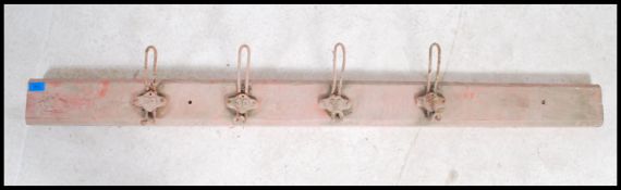 A set of four vintage mounted early 20th century coat hooks each having an individual cast number