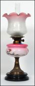 A 19th century brass and coloured stained glass cranberry glass reservoir oil lamp. Black ceramic